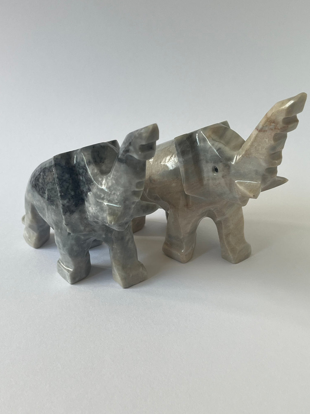 Two Elephant Sculptures against a white background